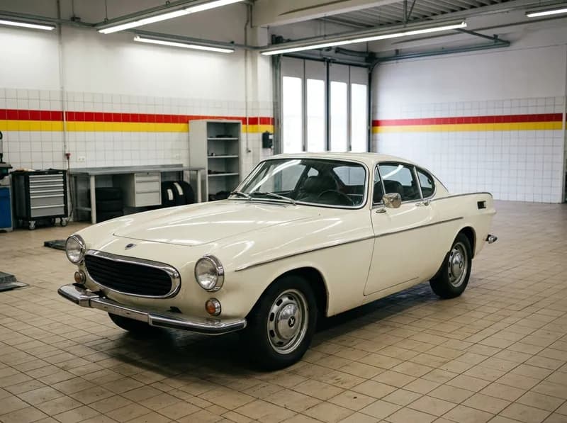 Um coupé clássico estacionado na oficina sob luzes fortes